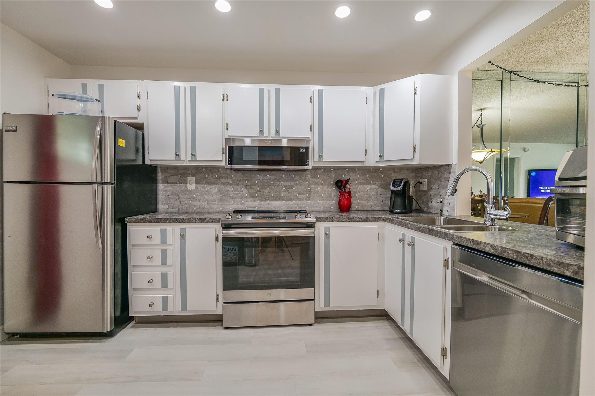 3930 Inverrary Boulevard, Unit 407D Lauderhill, FL 33319 - Photo 9 of 60 a kitchen with cabinets stainless steel appliances and a counter space