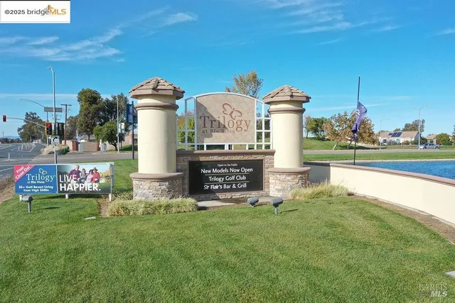a front view of a house with garden and statue