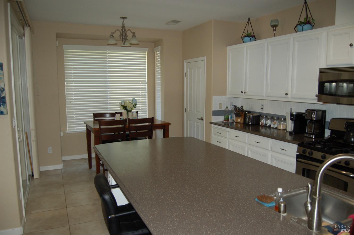 402 Palisades Drive Rio Vista, CA 94571 - Photo 3 of 12 a kitchen with a table chairs and a refrigerator