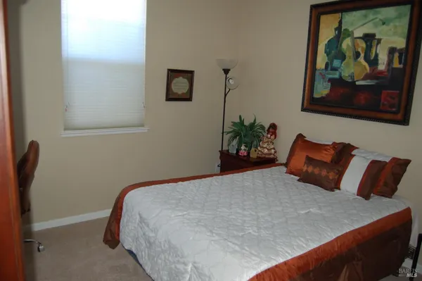 a bedroom with a bed and painting on the wall