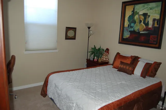 a bedroom with a bed and painting on the wall