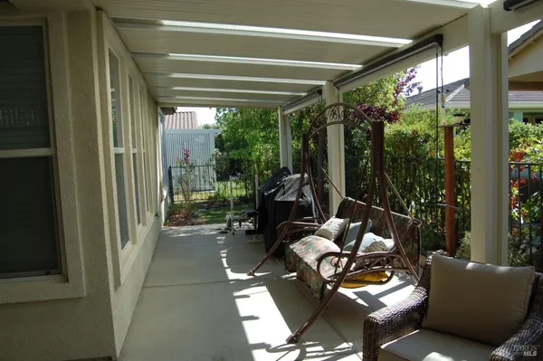 a living room with patio furniture and a potted plant