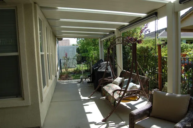 a living room with patio furniture and a potted plant