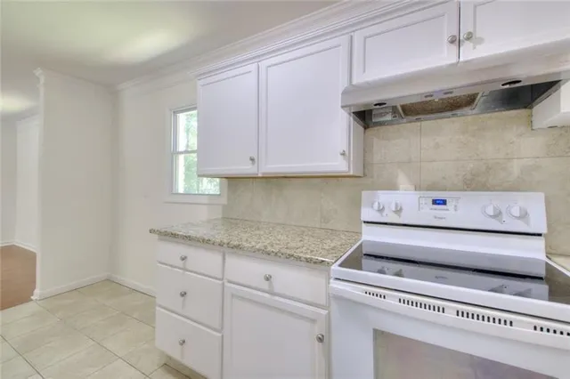a kitchen with granite countertop a sink and cabinets