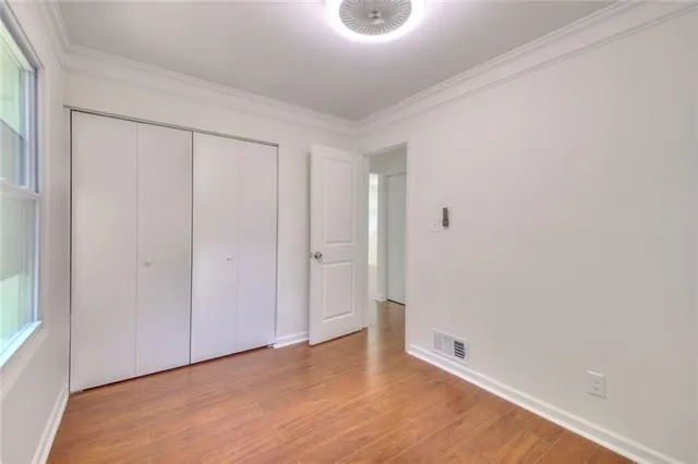 a view of an empty room with wooden floor