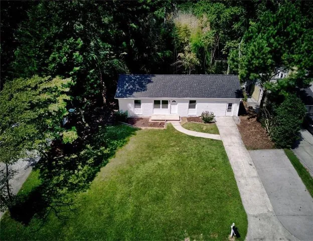 an aerial view of a house with a yard and swimming pool