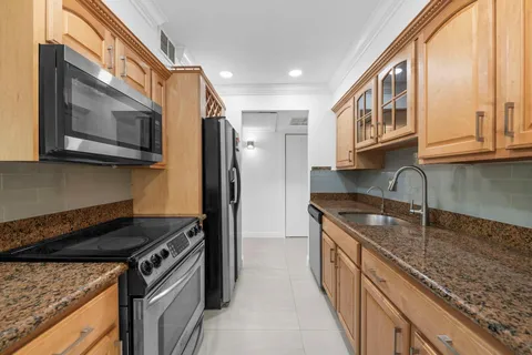 a kitchen with stainless steel appliances granite countertop a stove a sink and a microwave