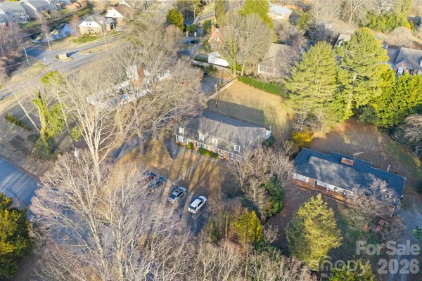 a aerial view of a house with a yard and large trees