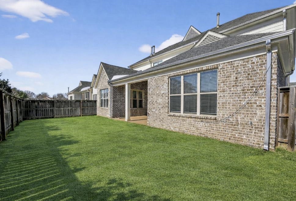 1421 Peyton Run Loop South Collierville, TN 38017 - Photo 4 of 29 Rear view of property featuring brick siding, a fenced backyard, and roof with shingles