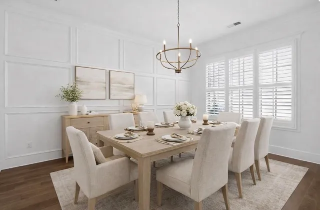 a view of a room with wooden floor white walls and a chandelier