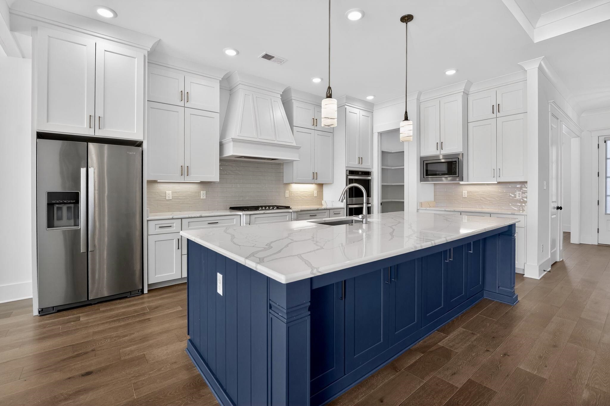 1421 Peyton Run Loop South Collierville, TN 38017 - Photo 7 of 29 Kitchen with appliances with stainless steel finishes, blue cabinetry, white cabinets, ornamental molding, and dark wood finished floors