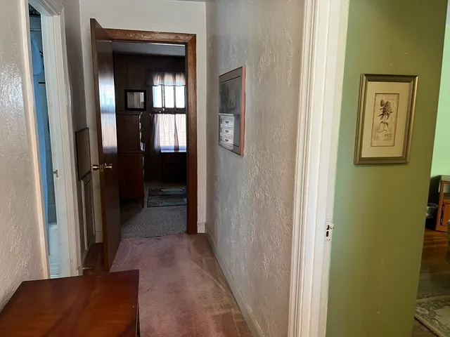 a view of a hallway with windows and closet