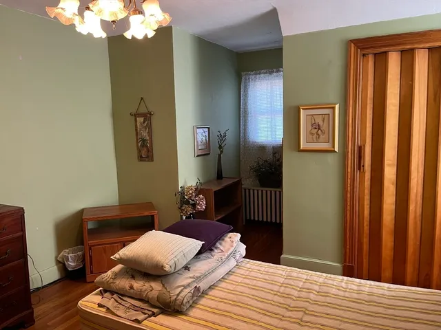 a bedroom with bed and wooden floor