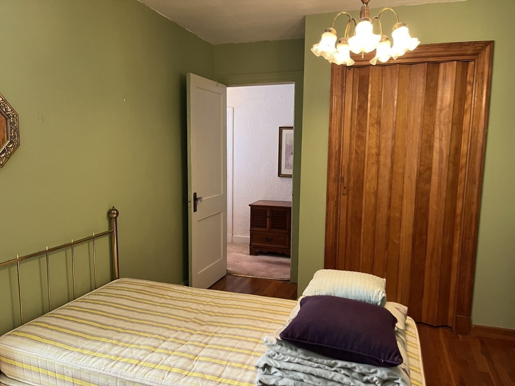 305 Harrington Way, Unit 1 Worcester, MA 01604 - Photo 14 of 21 a bedroom with a bed and a chandelier