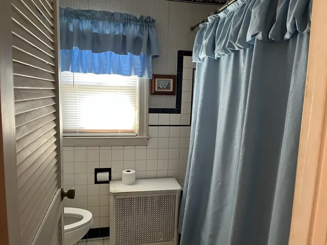 a bathroom with a toilet a sink and mirror