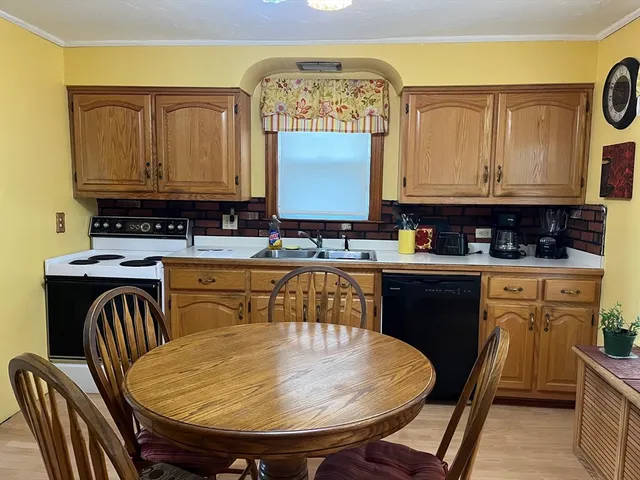 a kitchen with a table chairs sink and cabinets