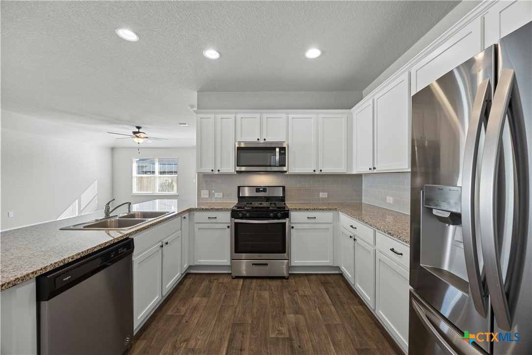 118 Rochester Lane Hutto, TX 78634 - Photo 11 of 33 a kitchen with granite countertop a refrigerator stove and sink