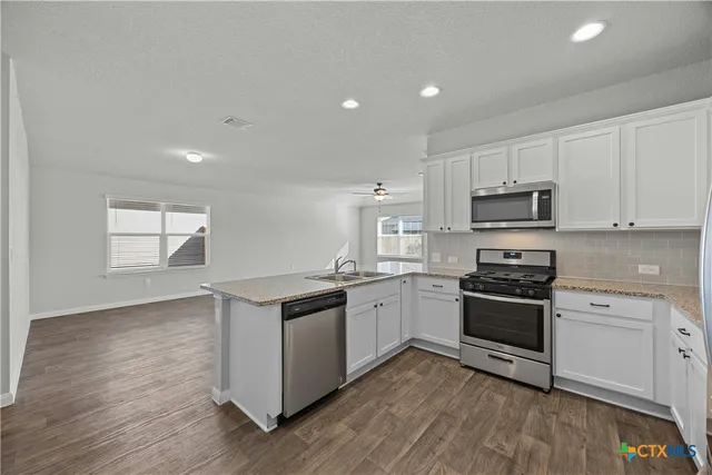 a kitchen with a stove a sink and a microwave