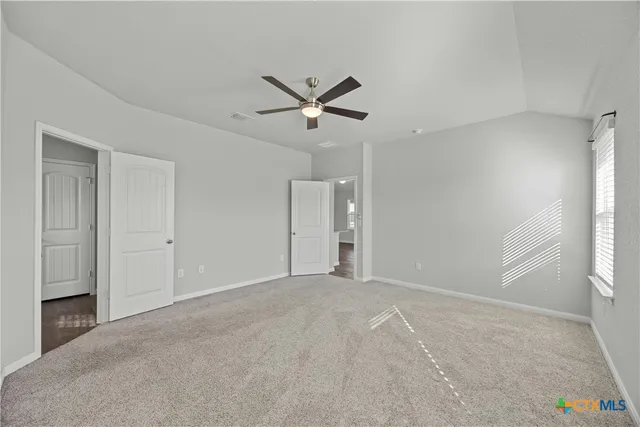 a view of a livingroom with a ceiling fan and window
