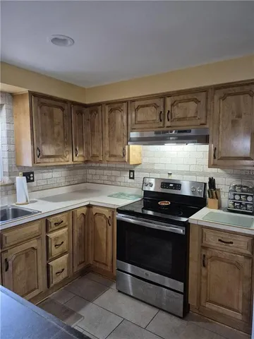 a living room with furniture a flat screen tv and a floor to ceiling window