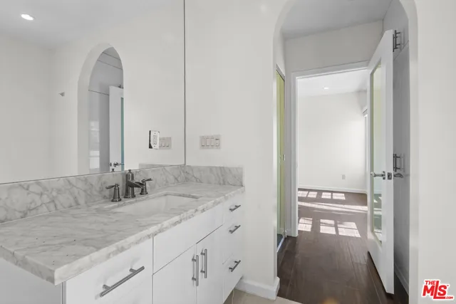 a bathroom with a granite countertop sink and a mirror