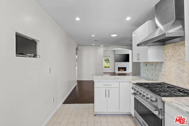 a kitchen with granite countertop a sink stove and cabinets