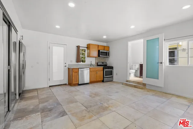 a view of a kitchen with stainless steel appliances granite countertop a stove and a refrigerator