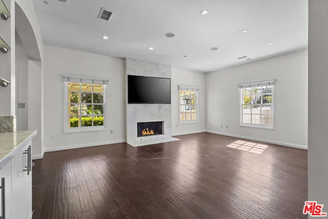 a view of a livingroom with furniture a fireplace and wooden floor