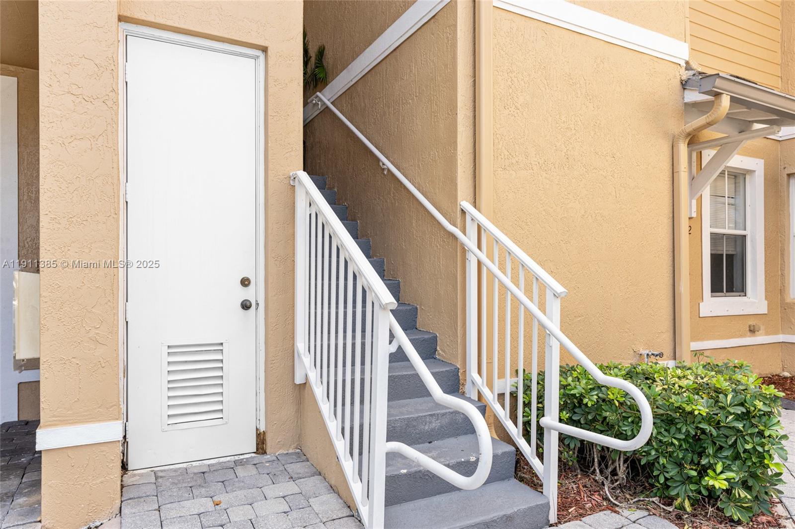 230 Southeast 29th Avenue, Unit 21 Homestead, FL 33033 - Photo 28 of 34 a view of staircase with railing and white walls