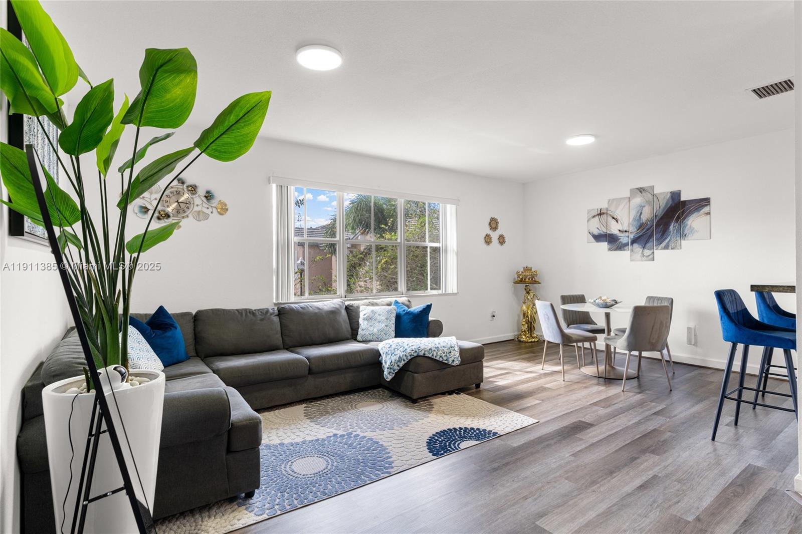 230 Southeast 29th Avenue, Unit 21 Homestead, FL 33033 - Photo 9 of 34 a living room with furniture a potted plant and a large window