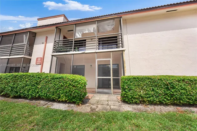 a front view of house with yard and trees around