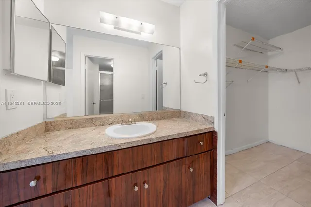 a bathroom with a granite countertop sink and a mirror