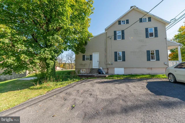 a front view of a house with a yard and trees