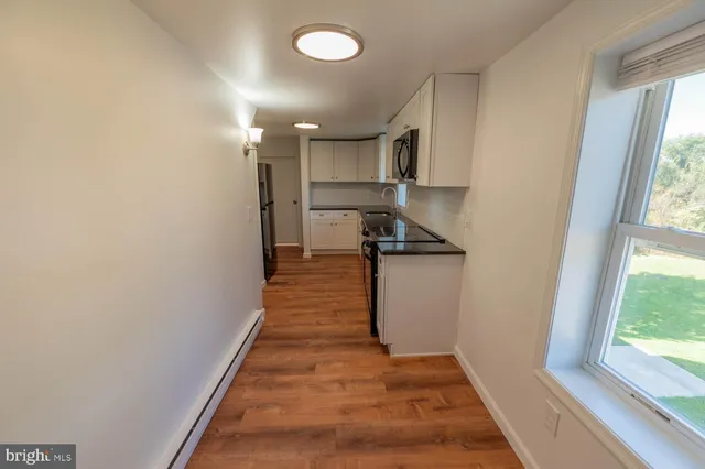 a view of a hallway with wooden floor and staircase