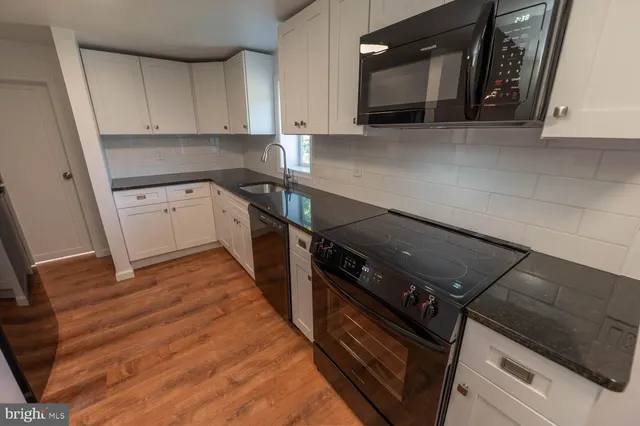 a kitchen with granite countertop a stove and a microwave