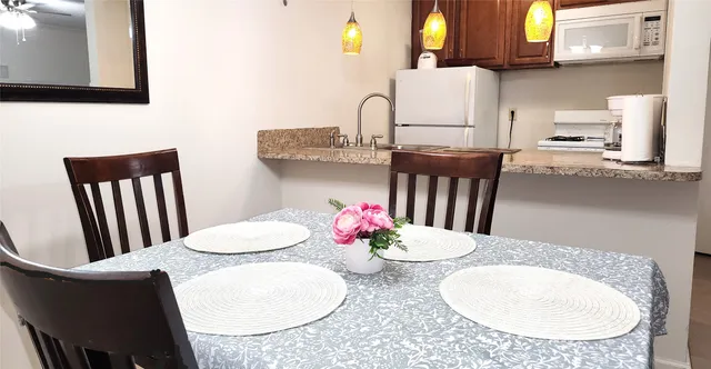a kitchen with a table chairs and a wooden floor