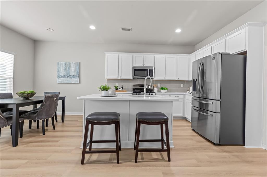 325 Winston Circle Canton, GA 30114 - Photo 11 of 38 a kitchen with kitchen island a dining table chairs stainless steel appliances and cabinets