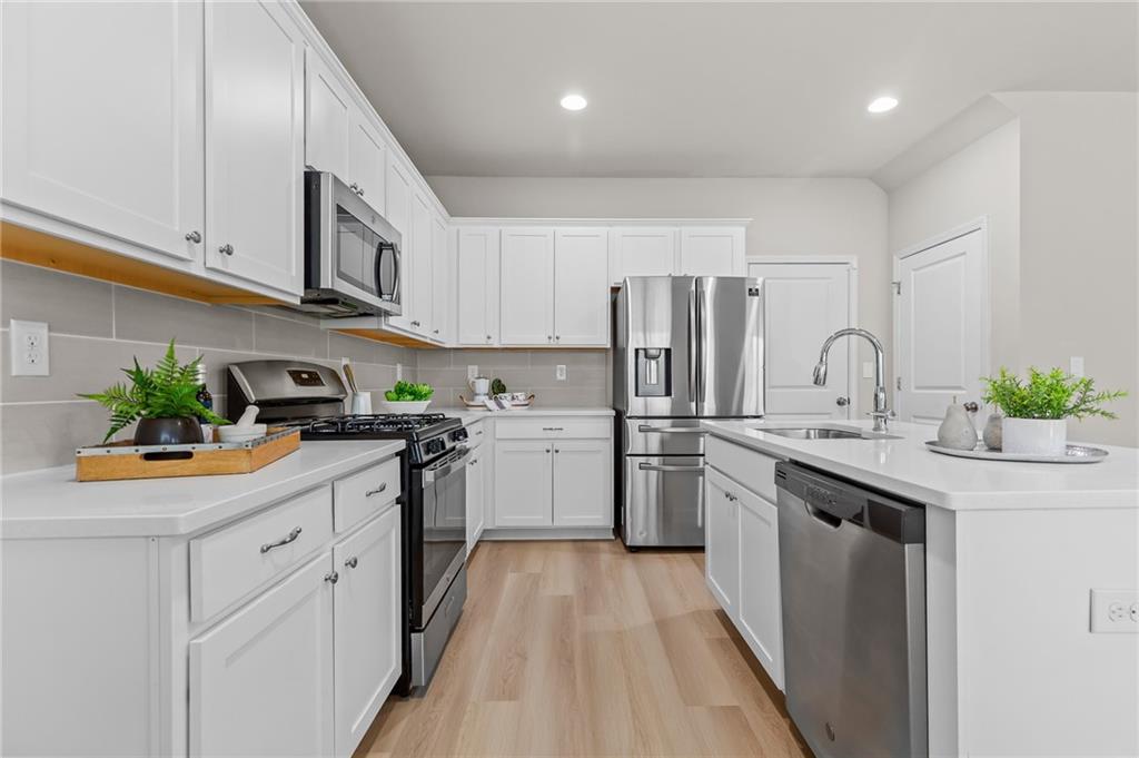 325 Winston Circle Canton, GA 30114 - Photo 14 of 38 a kitchen with white cabinets stainless steel appliances and sink