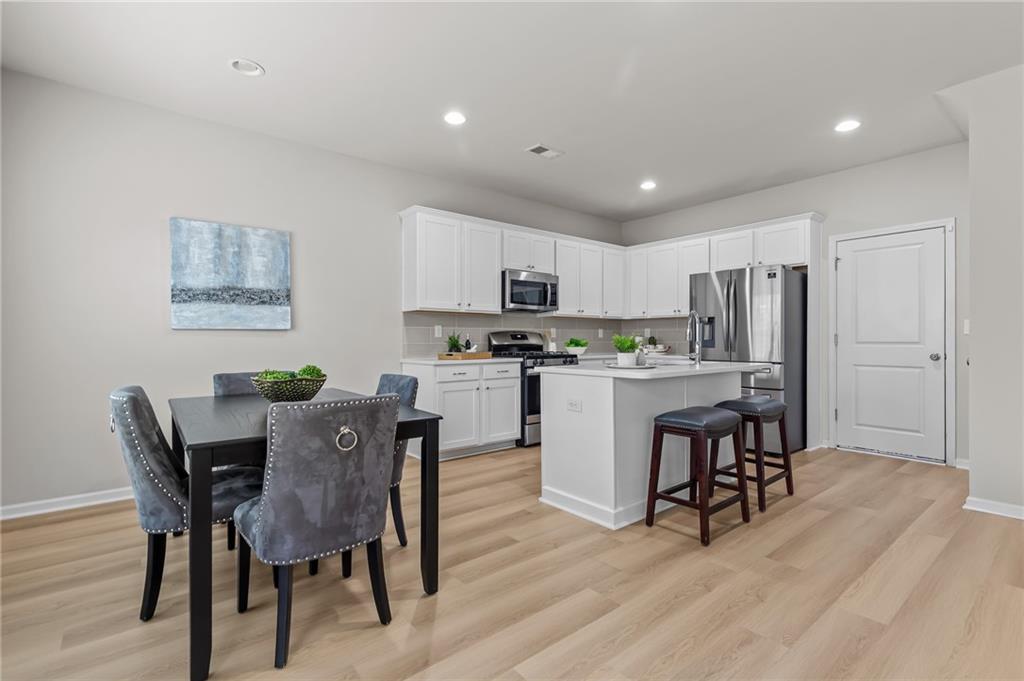 325 Winston Circle Canton, GA 30114 - Photo 10 of 38 a kitchen with kitchen island a dining table and chairs
