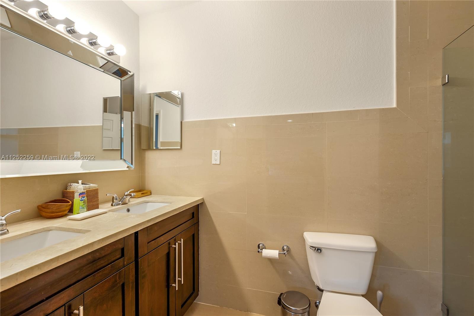 1757 Daytonia Road Miami Beach, FL 33141 - Photo 13 of 30 a bathroom with a toilet sink and mirror