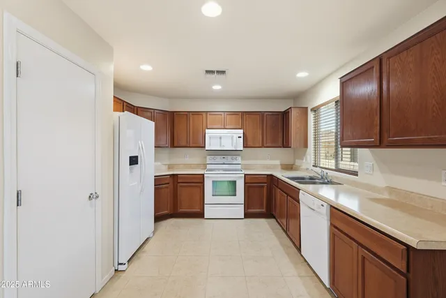 a large kitchen with stainless steel appliances granite countertop a sink and stove top oven
