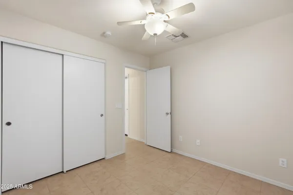 an empty room with a ceiling fan and a fan