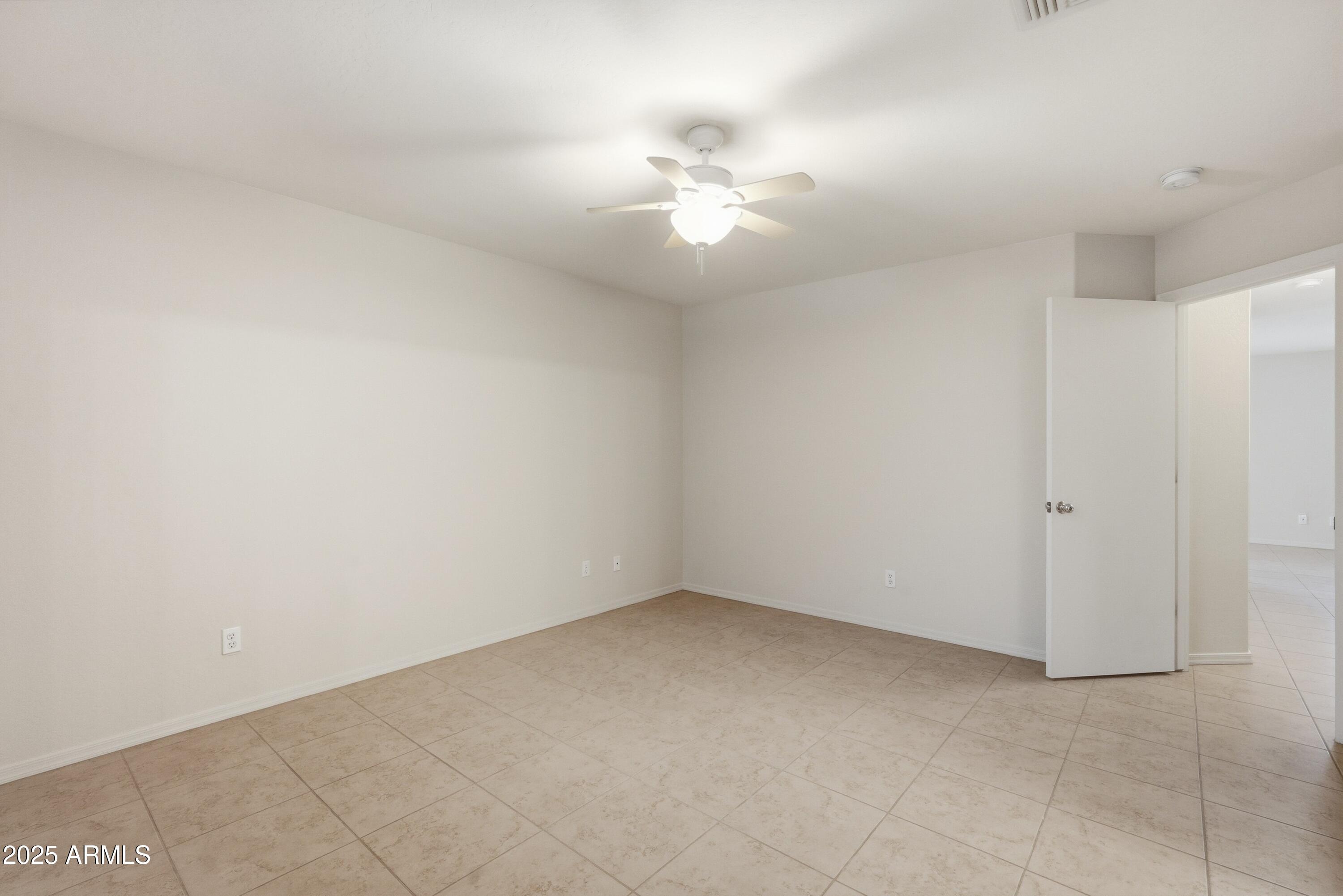 2101 South Meridian Road, Unit 210 Apache Junction, AZ 85120 - Photo 19 of 32 an empty room with a chandelier fan and windows