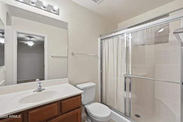 a bathroom with a sink a toilet a mirror and shower