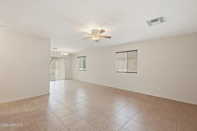 a view of an empty room with a ceiling fan and a window