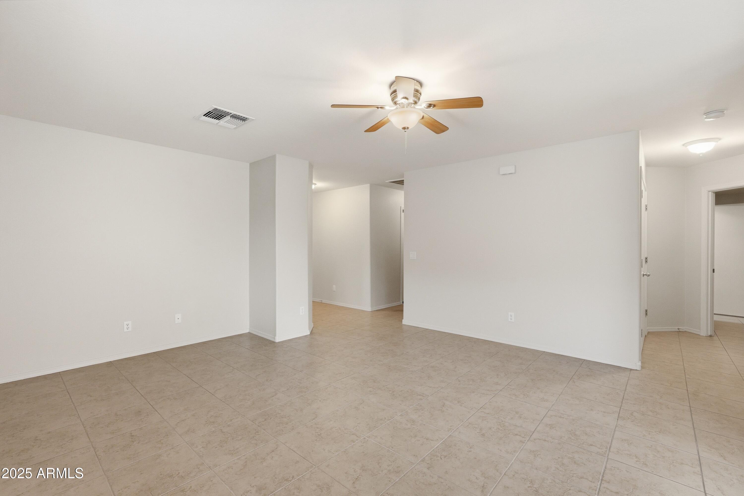 2101 South Meridian Road, Unit 210 Apache Junction, AZ 85120 - Photo 8 of 32 an empty room with chandelier fan and windows