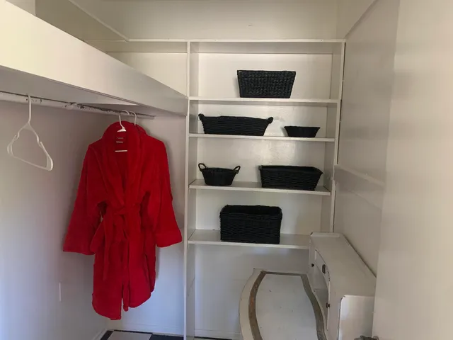 a view of walk in closet with clothes and shoes