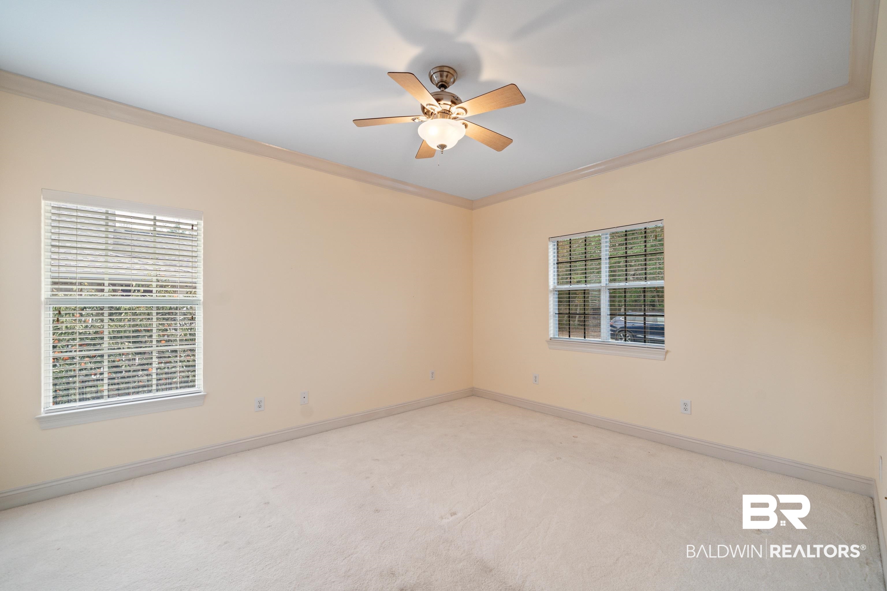 404 Savannah Lane Foley, AL 36535 - Photo 19 of 29 Unfurnished room with light carpet, plenty of natural light, baseboards, and crown molding