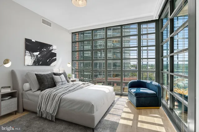 a bedroom with a bed a couch and a large window