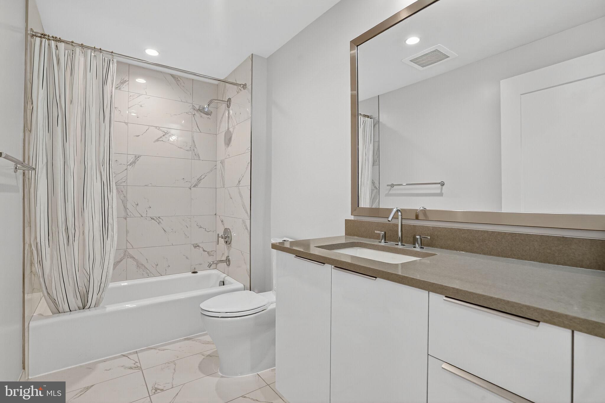 45 Sutton Square Southwest, Unit 509 Washington, DC 20024 - Photo 16 of 25 a bathroom with a granite countertop sink a toilet and shower